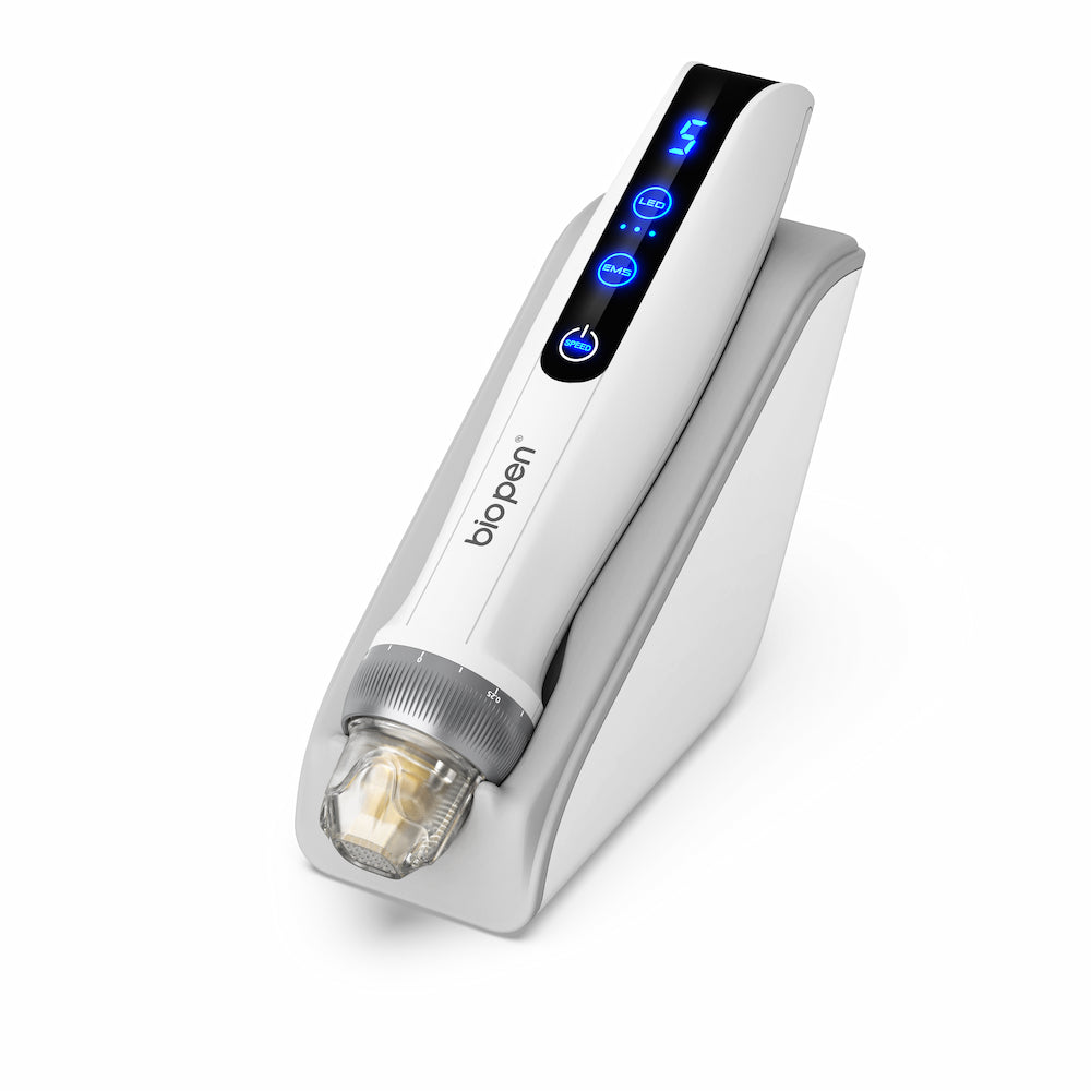 Hvid BioPen Q2 microneedling-pen placeret i en hvid stander, med blå digital LED-display og gennemsigtig nålmodul.